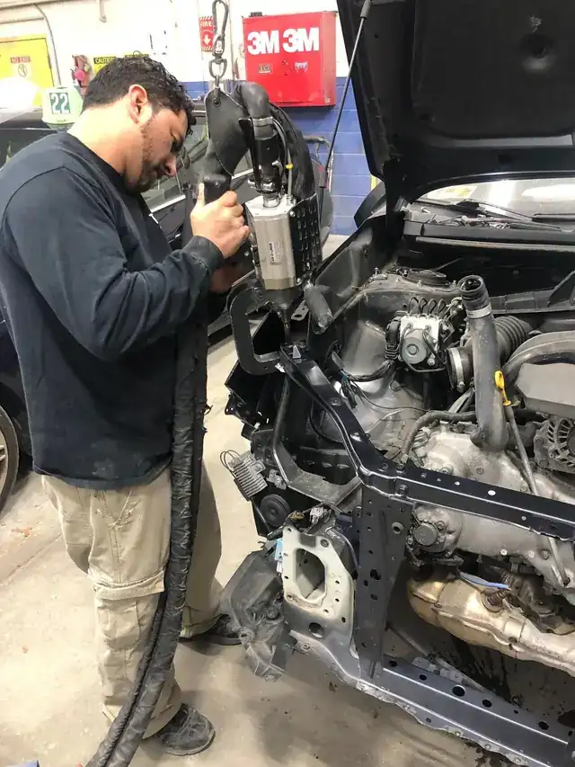A technician working in an engine bay