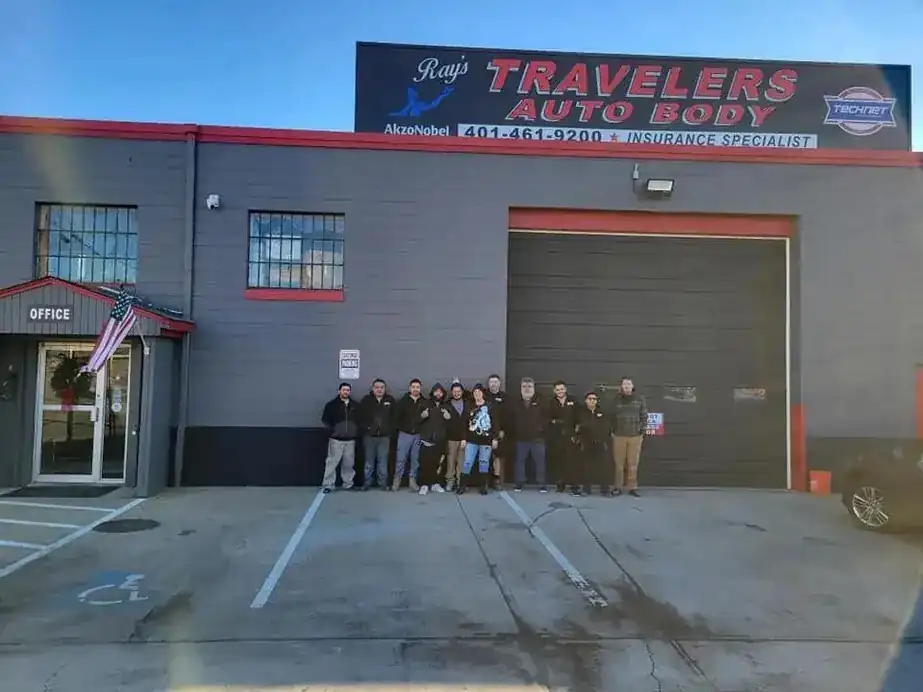 The Ray's Travelers Auto Body team lined up in front of the shop under the sign at 299 Allens Ave